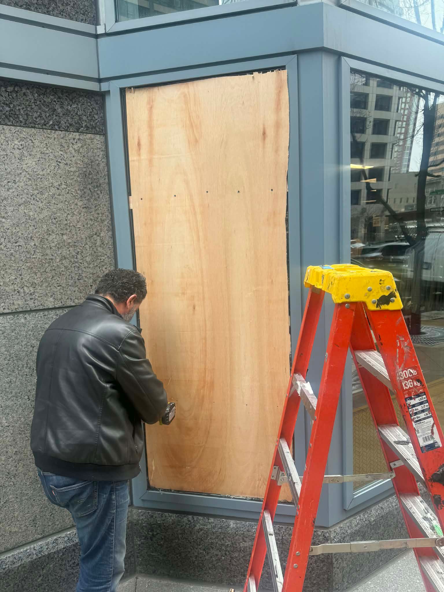 Plywood board-up securing a commercial storefront opening
